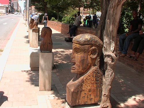 Wooden bustssculptures are mounted on bollards on streets in Joburg South Africa