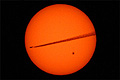 Airplane crossing the sun's face with giant heart-shaped sunspot active region 2529, photo taken from Hoboken, New Jersey