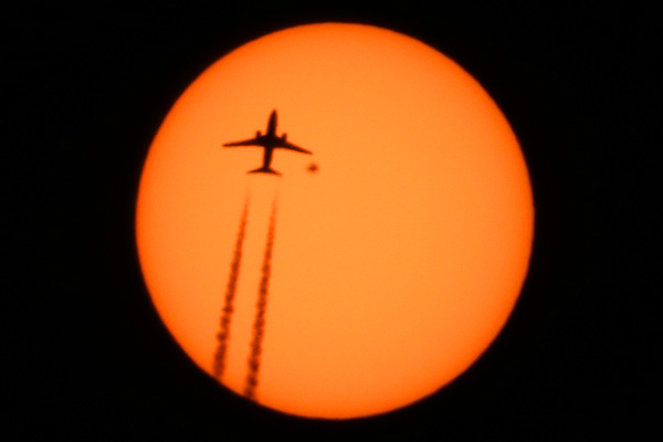 Airplane Boeing 737 flight WestJet 2773 from Trinidad and Tobago  to Toronto passing in front of the Sun with sunspot AR2529 above Manhattan New York on April 13 2016 photo Alexander Krivenyshev WorldTimeZone