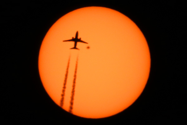 Airplane Boeing 737 flight WestJet 2773 from Port of Spain Trinidad and Tobago to Toronto Canada passing in front of the Sun with sunspot AR2529 high above Manhattan, New York on April 13, 2016 photo Alexander Krivenyshev WorldTimeZone
